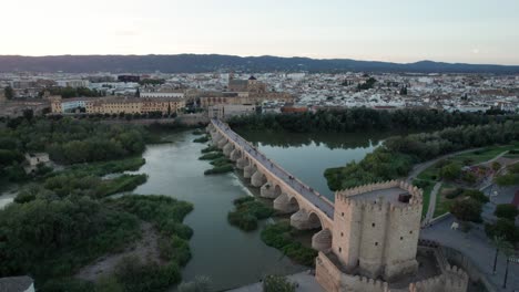 vista aérea del puente romano y la mezquita-catedral en córdoba, españa durante la hora azul