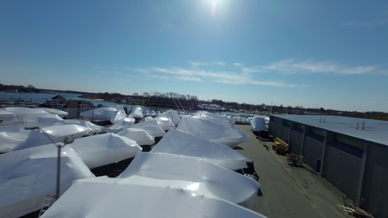 Boats that are covered in white shrink wrap for winter storage or protection. Porter River Danvers Massachusetts.