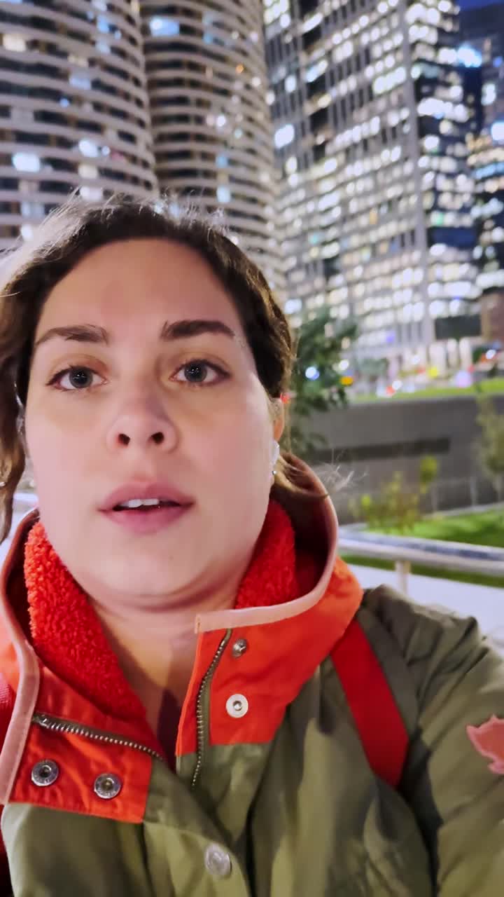 Influencer riprende un vlog di notte in città con grattacieli
