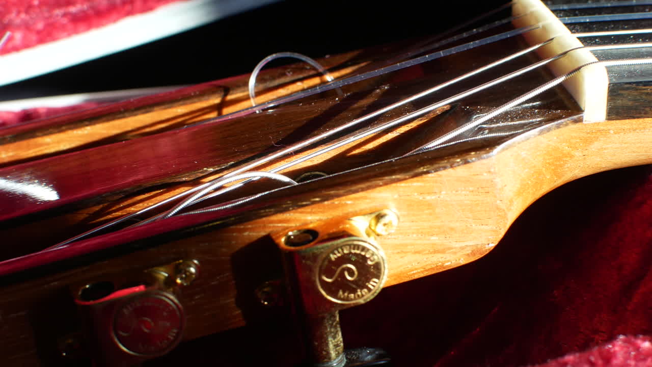Guitar headstock and tuning keys with strings close up sliding shot