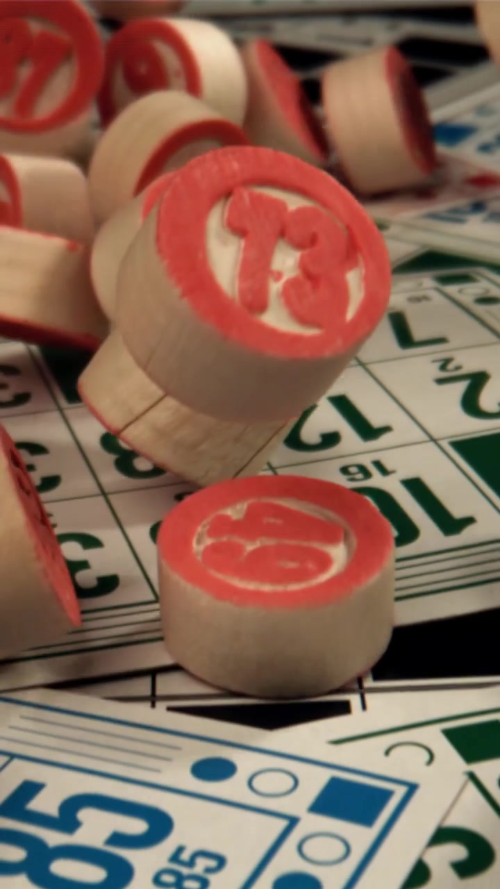 Primo piano di gettoni da bingo rossi che cadono su cartelle da gioco