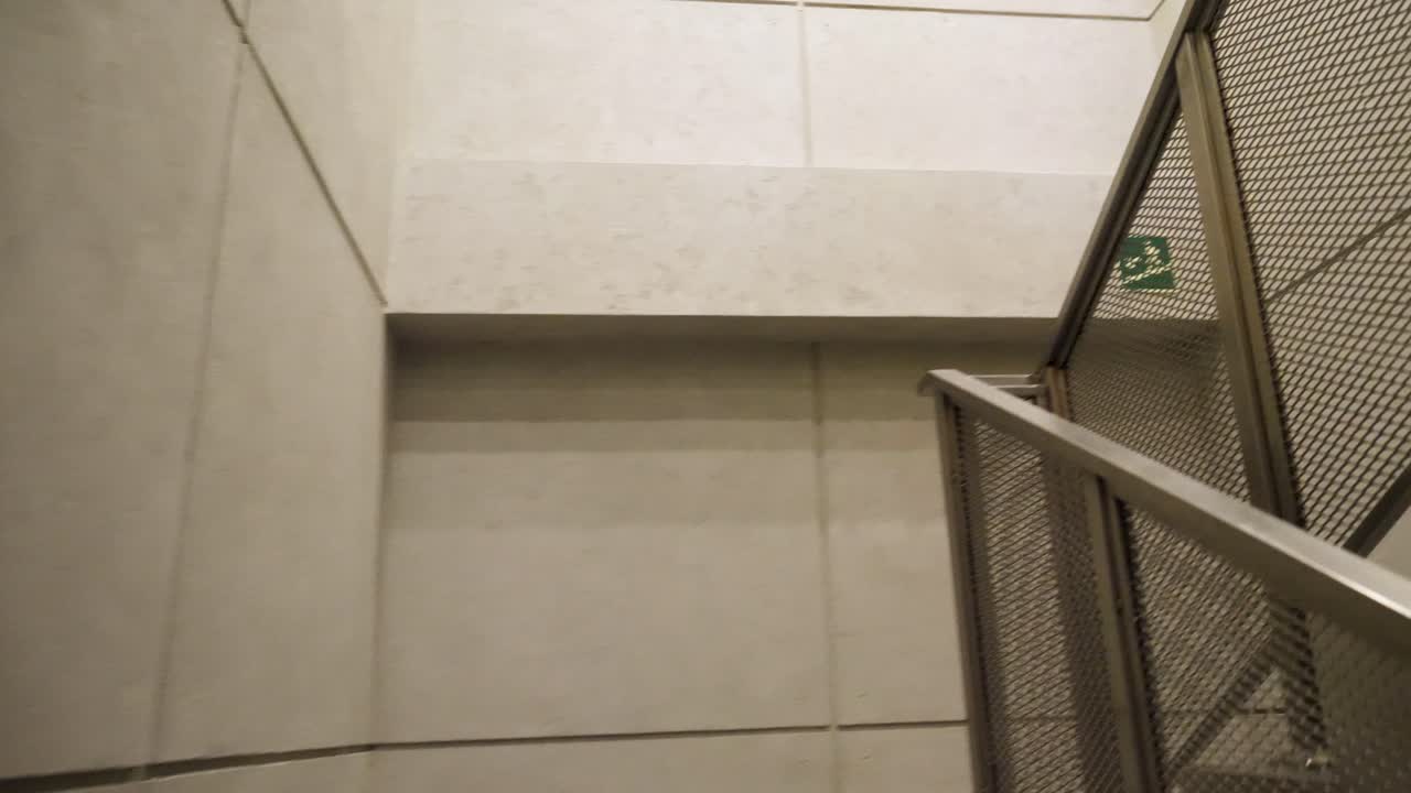 escalera moderna con barandilla de malla y paredes de hormigón