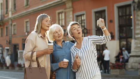 Drei-Schöne-Alte-Frauen-Lächeln,-Während-Sie-Ein-Selfie-Foto-Mit-Der-Smartphone-Kamera-Auf-Der-Straße-Im-Stadtzentrum-Machen