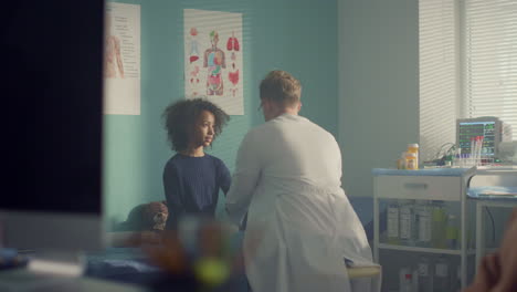 Madre-Observando-El-Examen-Médico-De-Su-Hija-En-El-Hospital.-Visita-Familiar-Al-Médico.