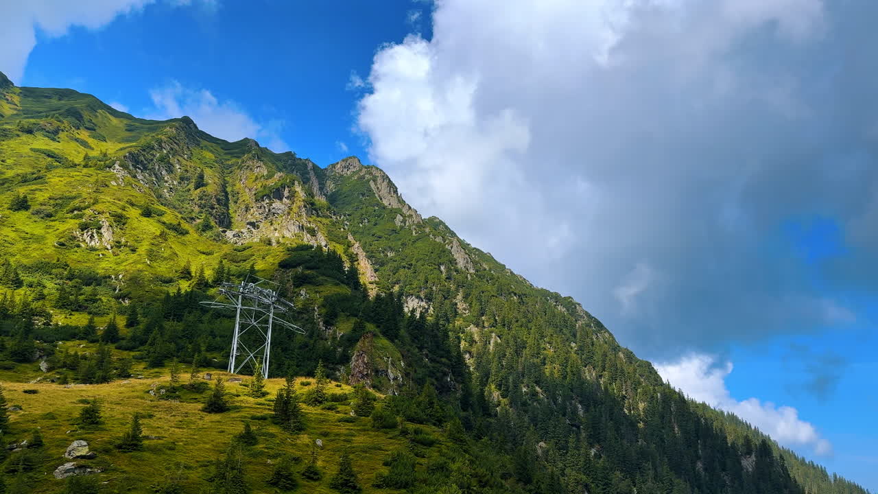 Waterfall near the Transfagarasan road. Drone view of a waterfall cascading down the green slopes of the Carpathian Mountains near the Transfagarasan highway in Romania