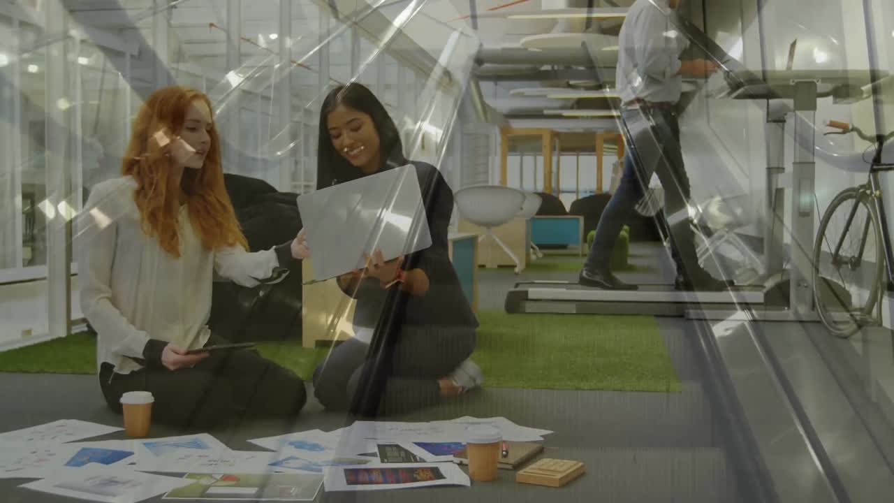 Animation of office building over businesswomen brainstorming and talking in modern office