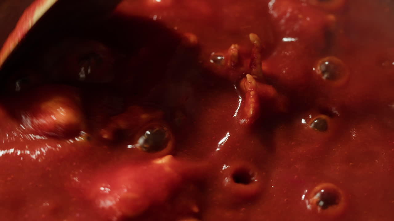 Chicken in tomato sauce is boiling on a frying pan with spices. Cooking tomato sauce curry with chicken fillet. Traditional Italian Mexican Asian dish. High quality studio shot for cafe, restaurant close up.