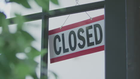 an employee flips a sign on a store window