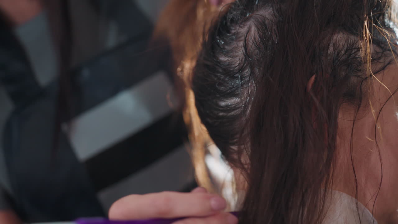 섬세한 붓놀림과 꼼꼼한 커버로 헤어라인과 귀 가장자리를 따라 작은 브러시로 염색약을 바르는 백인 컬러리스트, 브러시 팁과 뿌리 부분의 클로즈업, 조용하고 집중된 미용실의 순간