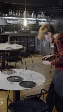 man setting tables in a restaurant