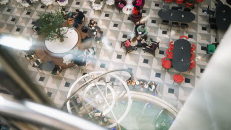 overhead view of a mall cafeteria, showing an arrangement of chairs and tables with people seated and interacting social atmosphere and modern interior design of a public space within a shopping mall