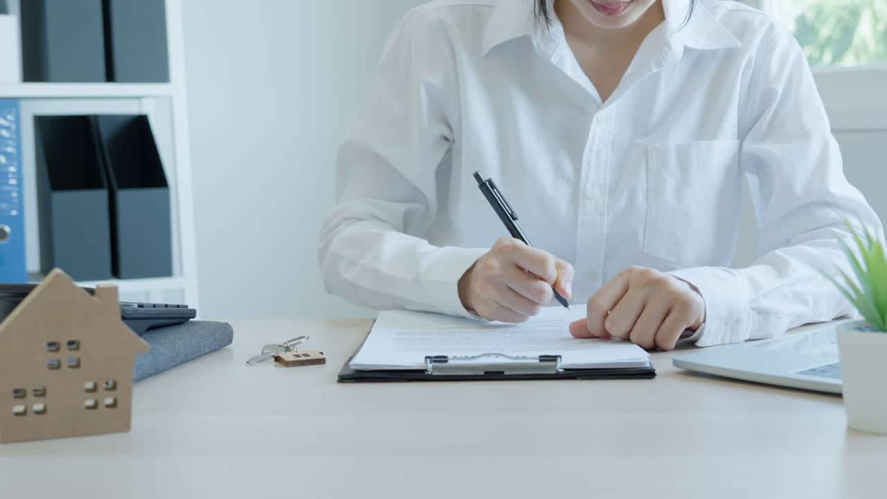 corredor de seguros de vivienda o vendedor que tiene una llave de la casa dada a un nuevo propietario. la agencia revisa los detalles del documento antes de firmar el contrato. venta de casas, bienes raíces y concepto de propiedad.