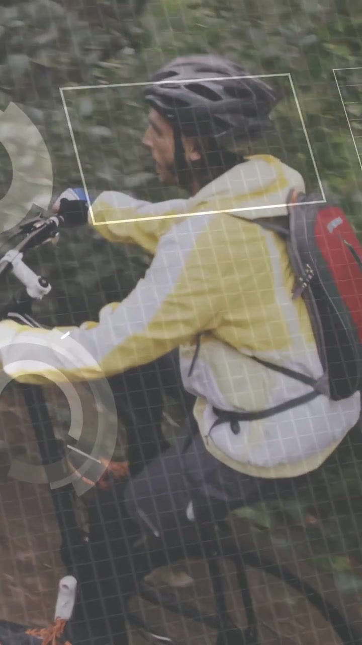 Vertical video: Male cyclist pedaling trail, sports HUD scrolling, lifting wheel clearing obstacle