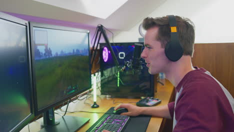 man gaming at home sitting at desk wearing headphones for live stream