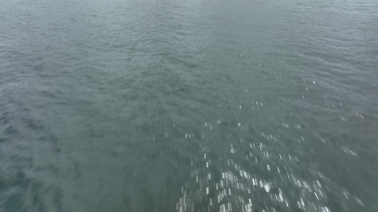 toma aérea que se eleva sobre el océano pacífico comenzando inclinada hacia abajo pero eventualmente inclinándose hacia arriba para revelar la isla whidbey