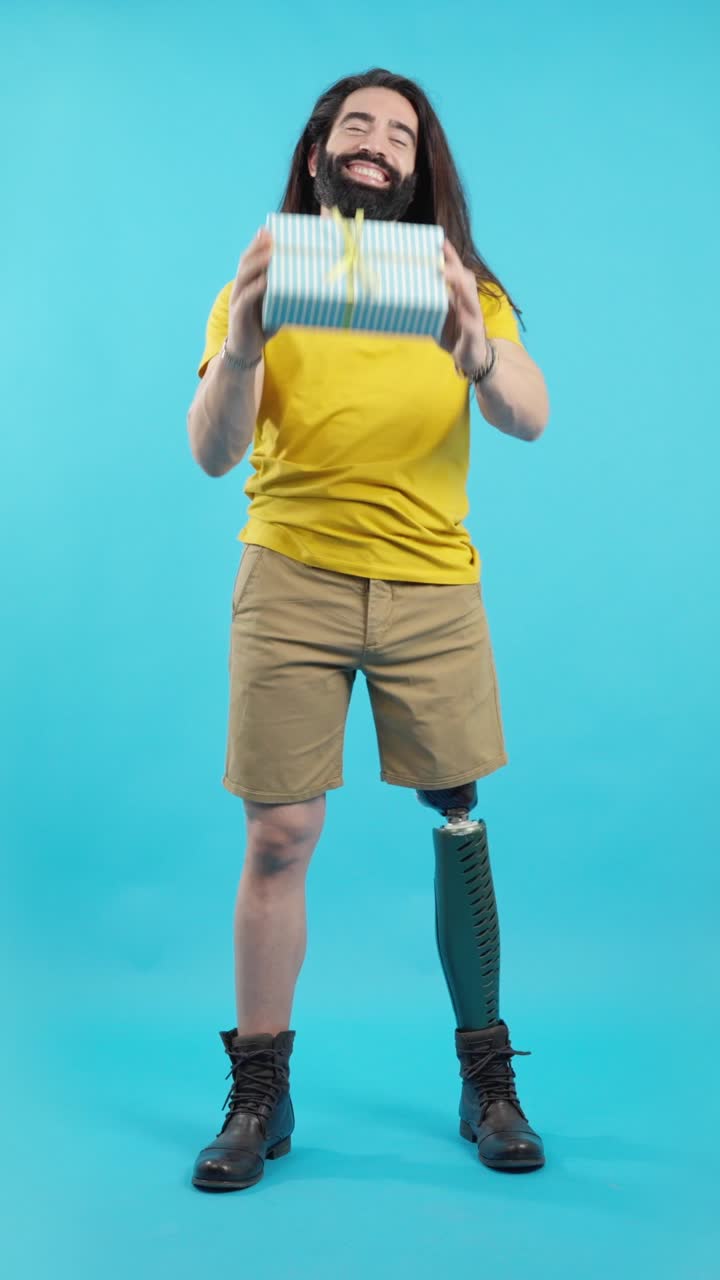 Happy Man with Prosthetic Leg Posing with a Gift and Books