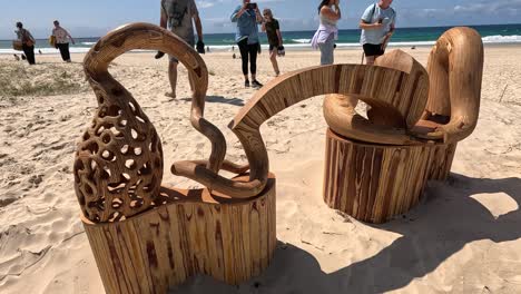 esculturas de madera con personas en el fondo