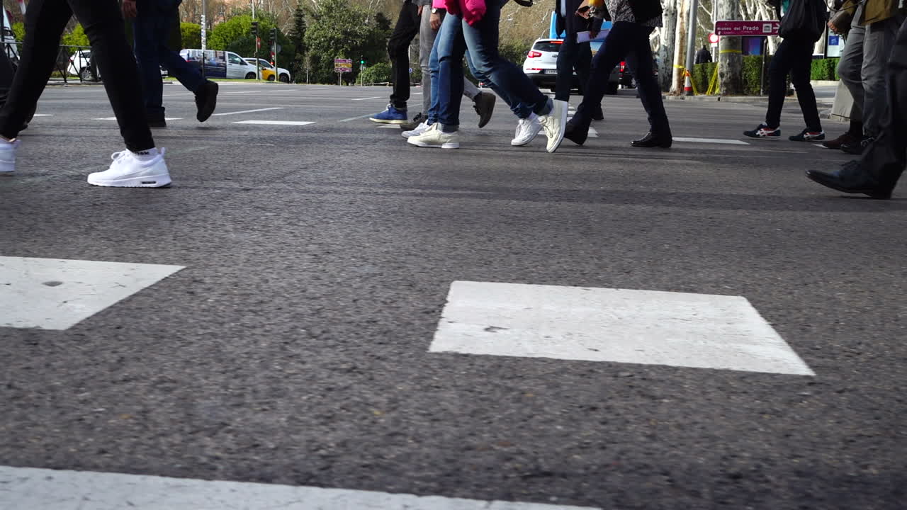Persone attraversano la strada sulle strisce pedonali. Rallentatore. Pedoni attraversano la strada. Rallentatore.