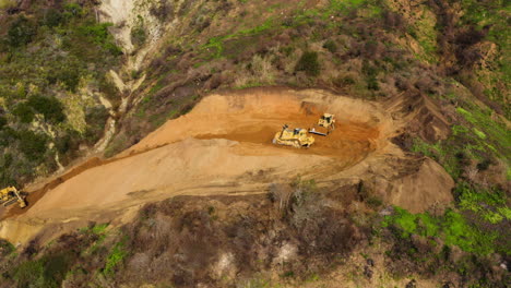 earthmoving machine driving on rural dirt road at rat creek washout, big sur, us, aerial