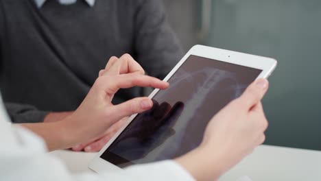 handheld view of doctor showing the results of the radiology