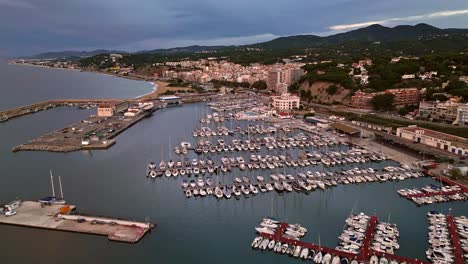 Vista-Aérea-Del-Puerto-Deportivo-De-Arenys-De-Mar-Con-Población-Revelada-Al-Fondo