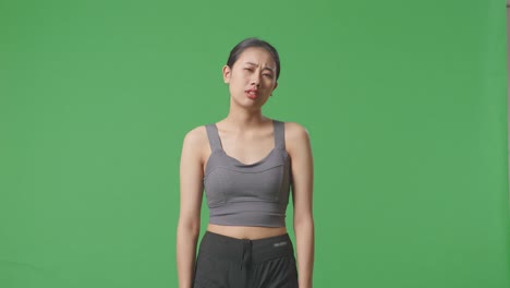 스포츠 의류 를 입은 여자 가 아래 를 바라보며, 스튜디오 에서 촬영