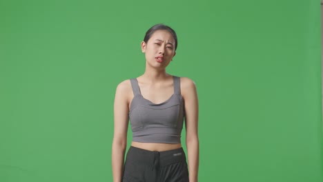 woman in sportswear looking down, studio shot