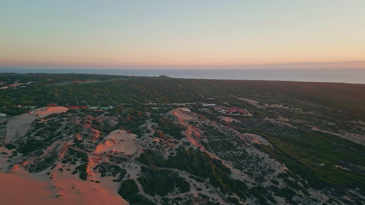 Drone coastal dunes sunset. Aerial blend urban interface with natural landscape