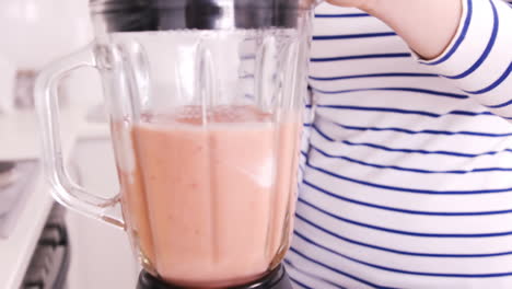cerca de una mujer preparando jugo de fruta