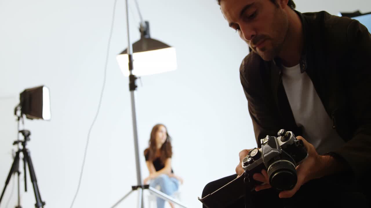 fotógrafo de sexo masculino poniendo el rollo de película en la cámara 4k