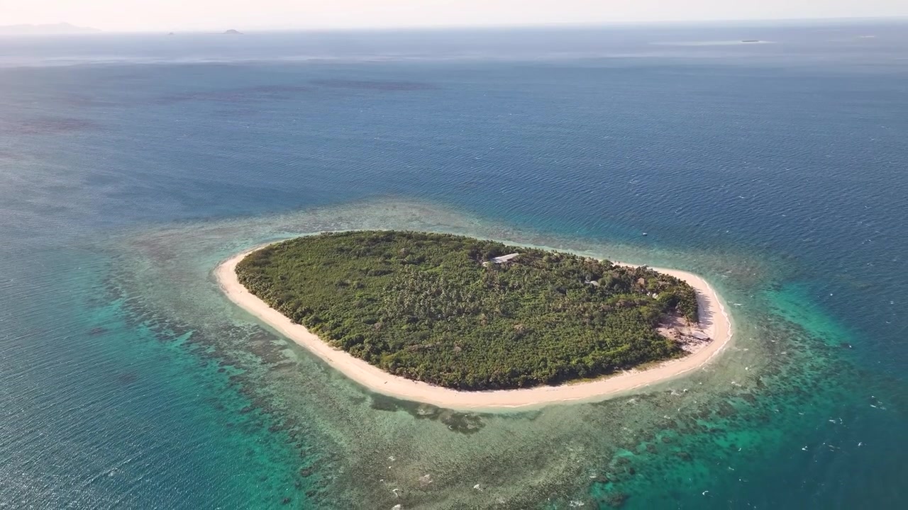 Isola paradisiaca con barriera corallina, spiaggia sabbiosa e foresta tropicale nell'Oceano Pacifico, Fiji. Drone.