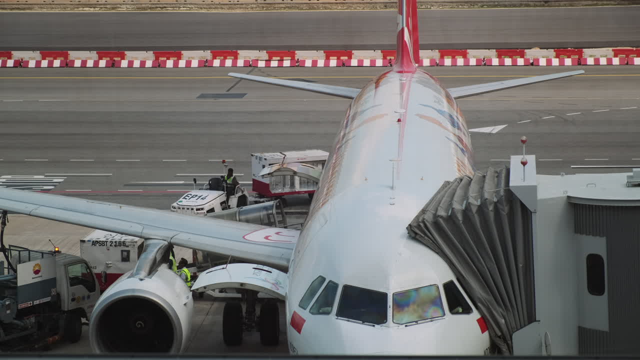 Airplane at Airport Gate with Ground Crew