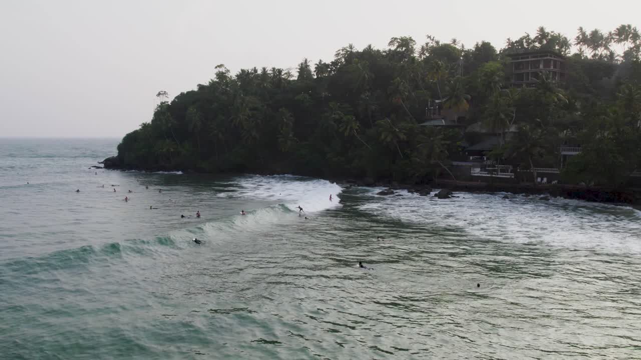 Surfisti in un paradiso tropicale: vista aerea di onde oceaniche e palme