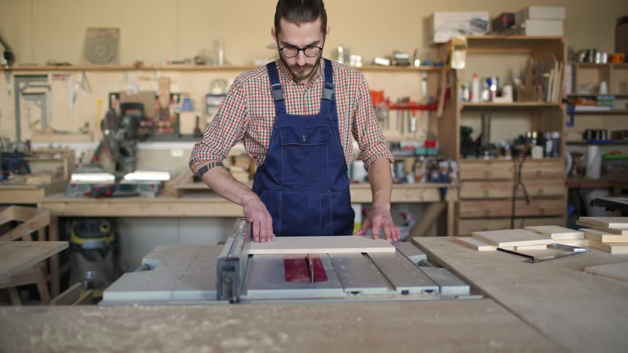 joven carpintero aserrándose a la tabla de madera