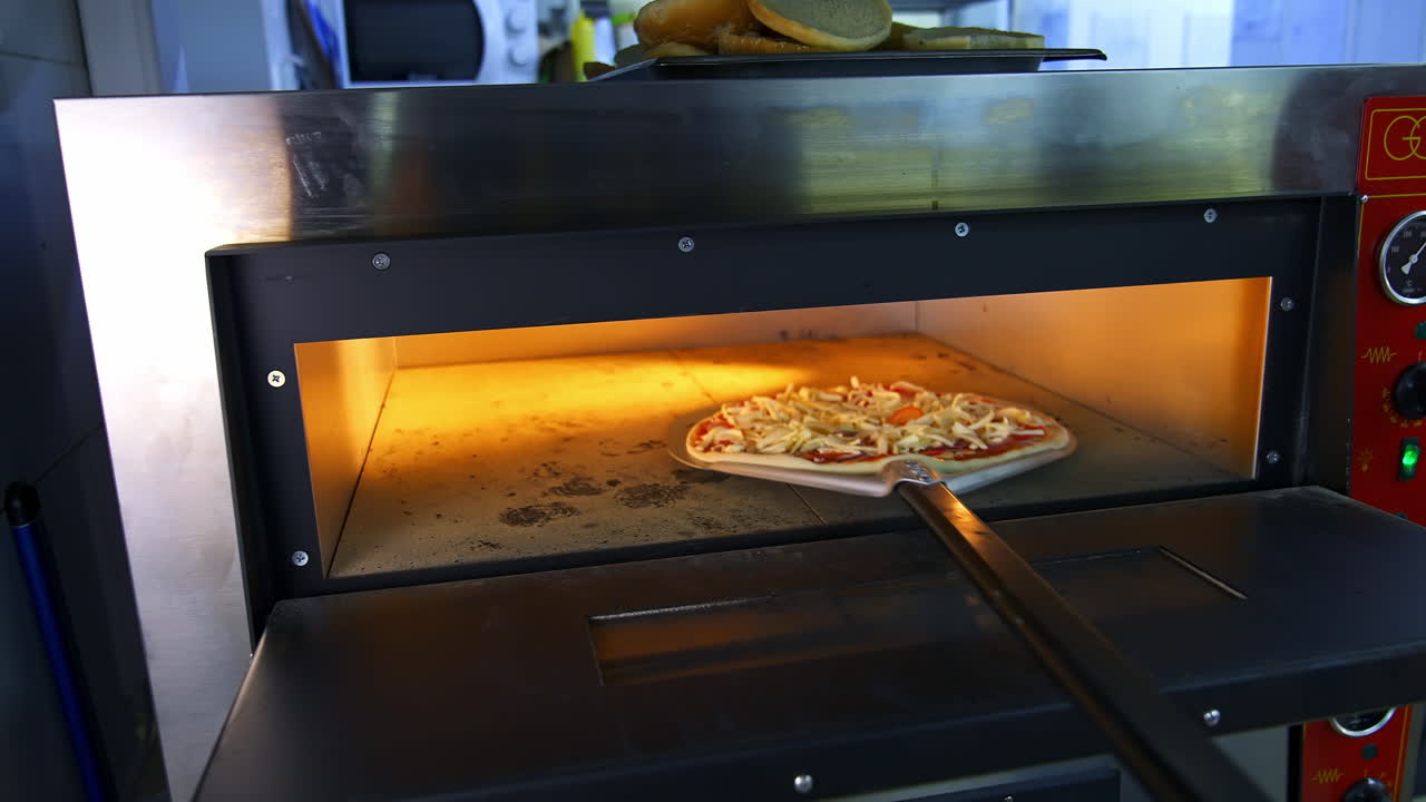 Freshly Prepared Pizza on a Wooden Table in a Cafe. Appetizing hot pizza close-up on the background of the interior of a modern restaurant.