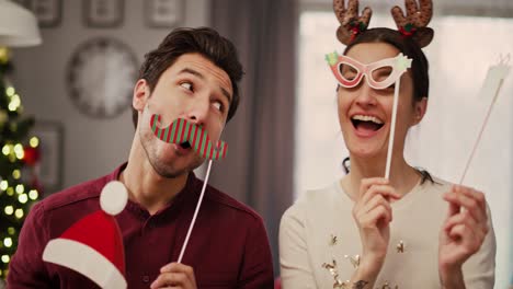 handheld view of playful couple in christmas masks