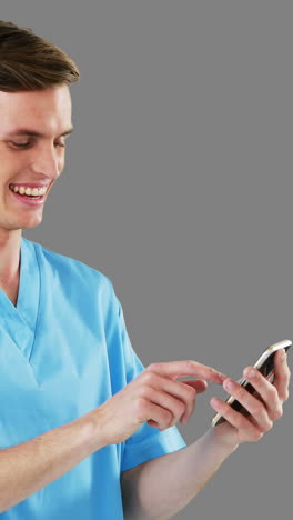 smiling surgeon using mobile phone