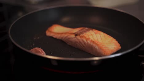 grilling a slice of salmon on a pan