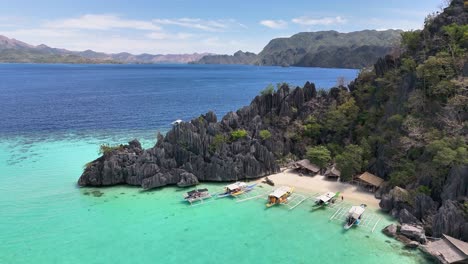 drone shot of the idylic turquoise waters in smith point beach, with boats coron, philippines