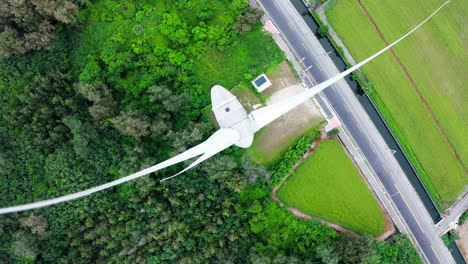 aerial top down shot of rotating wind turbine in rural landscape in china during daytime