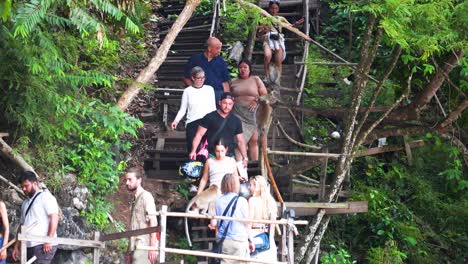 group of people walking down wooden stairs