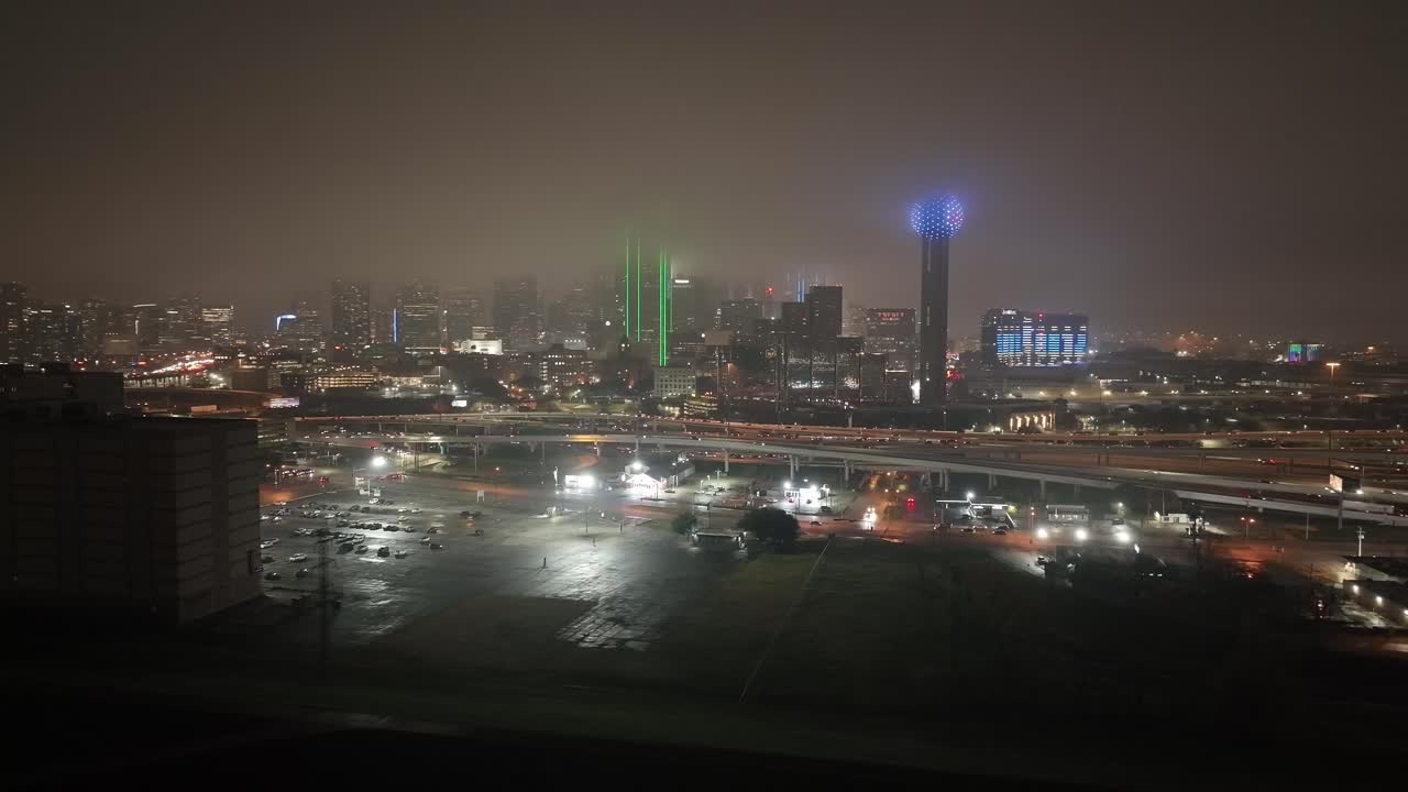 el horizonte de dallas, texas por la noche con tiempo de niebla y video de drones dando vueltas