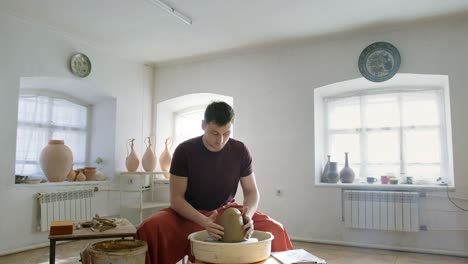 pottery artist working on a clay pot on a pottery wheel