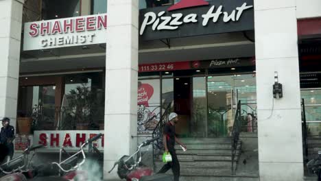 experience the tantalizing charm of a pizza hut from a captivating slow-motion close-up, showcasing a welcoming shopkeeper stepping outside to greet you.