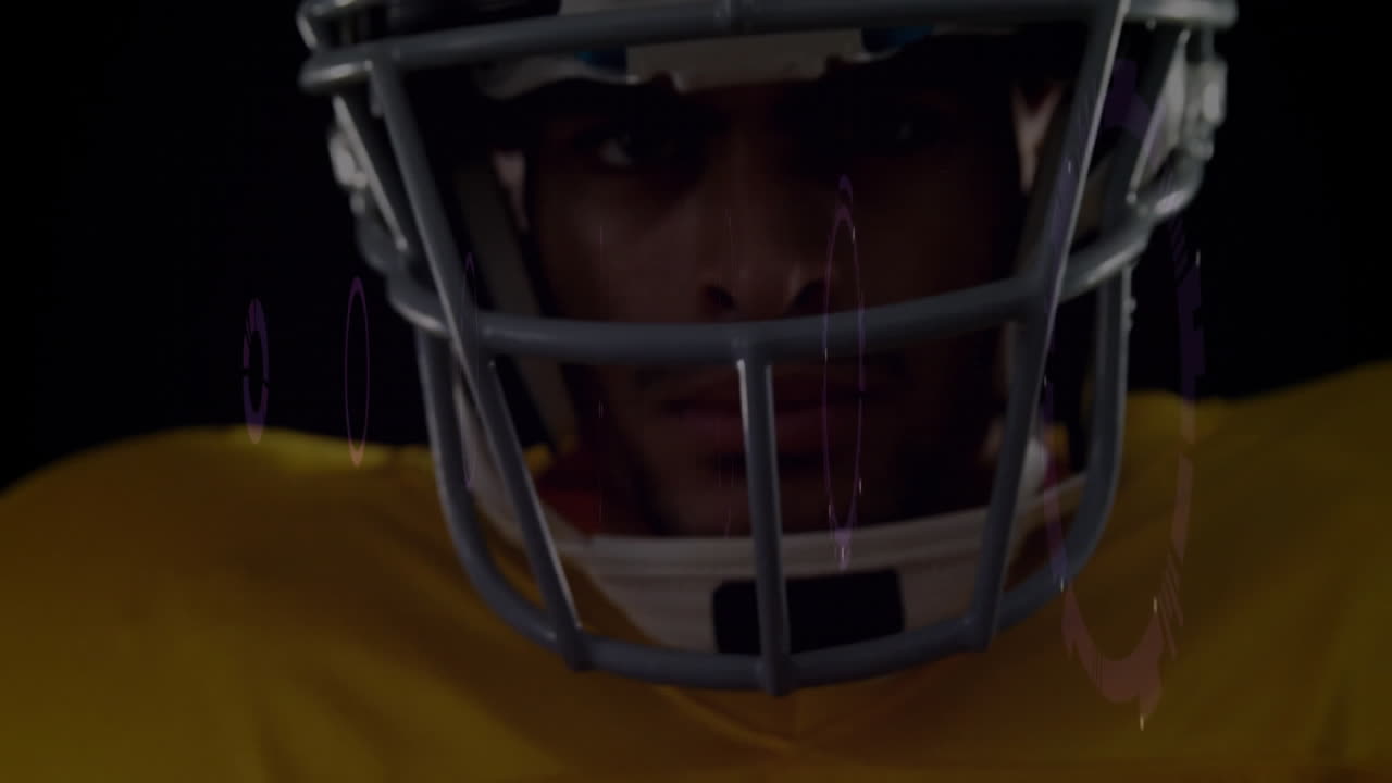 Giocatore di football americano con il casco e la maglia gialla, concentrato e determinato sul campo.