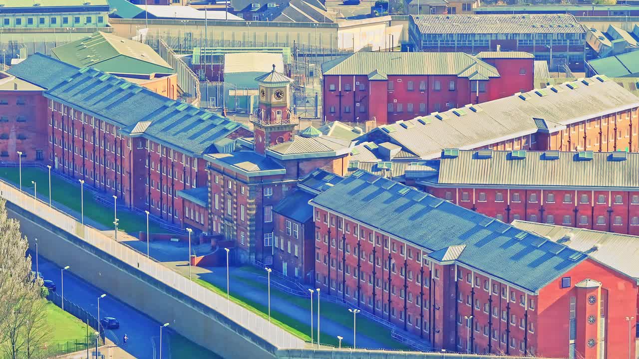 Aerial view of the red brick HM Prison in Wakefield, Yorkshire, England, showcasing its fortified walls and secure layout within the urban environment.