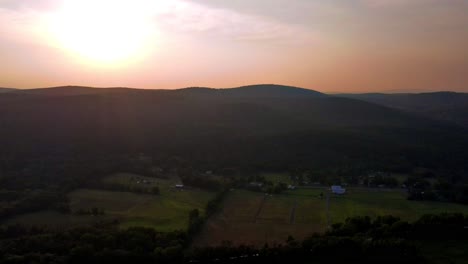 aerial drone video footage of a golden hour summer sunset in a green, vibrant rural appalachian mountain valley with beautiful light. in particular, this is in new york's hudson valley
