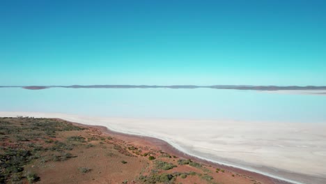 white colored lake gairdner, beautiful scenery from salt large lake, australia, drone flying backwards