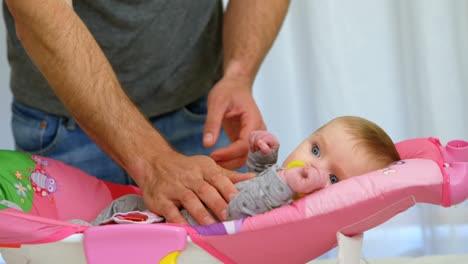 padre poniendo a su bebé a dormir en la cama de bebé 4k