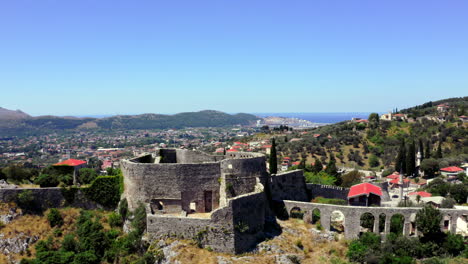 Aerial-4k-shot-of-the-aqueduct-and-the-old-fortress-of-Stari-Bar-in-Montenegro-with-the-Bar-city-behind-on-a-cloudless-sunny-summer-day